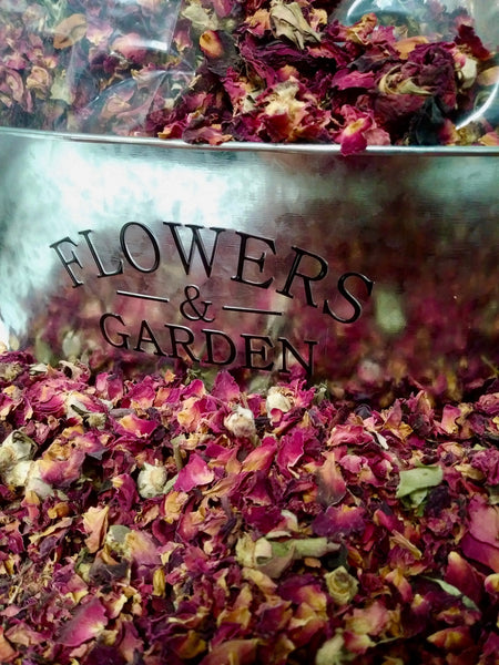 silver bucket full of red rose buds and petals