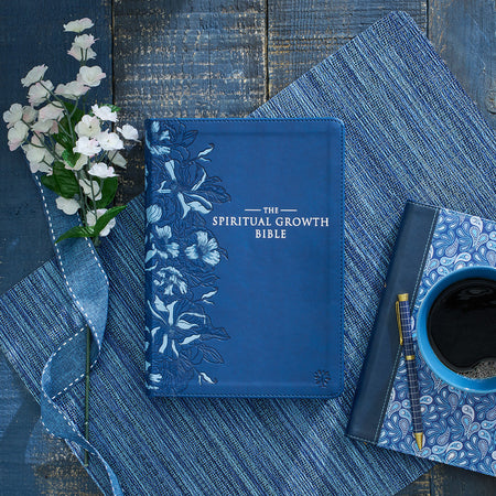 Beautiful dark blue bible with sliver lettering and floral design down the side of the bible