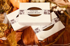 dark color brown soap in a white box in a Fall setting of orange leaves and vines